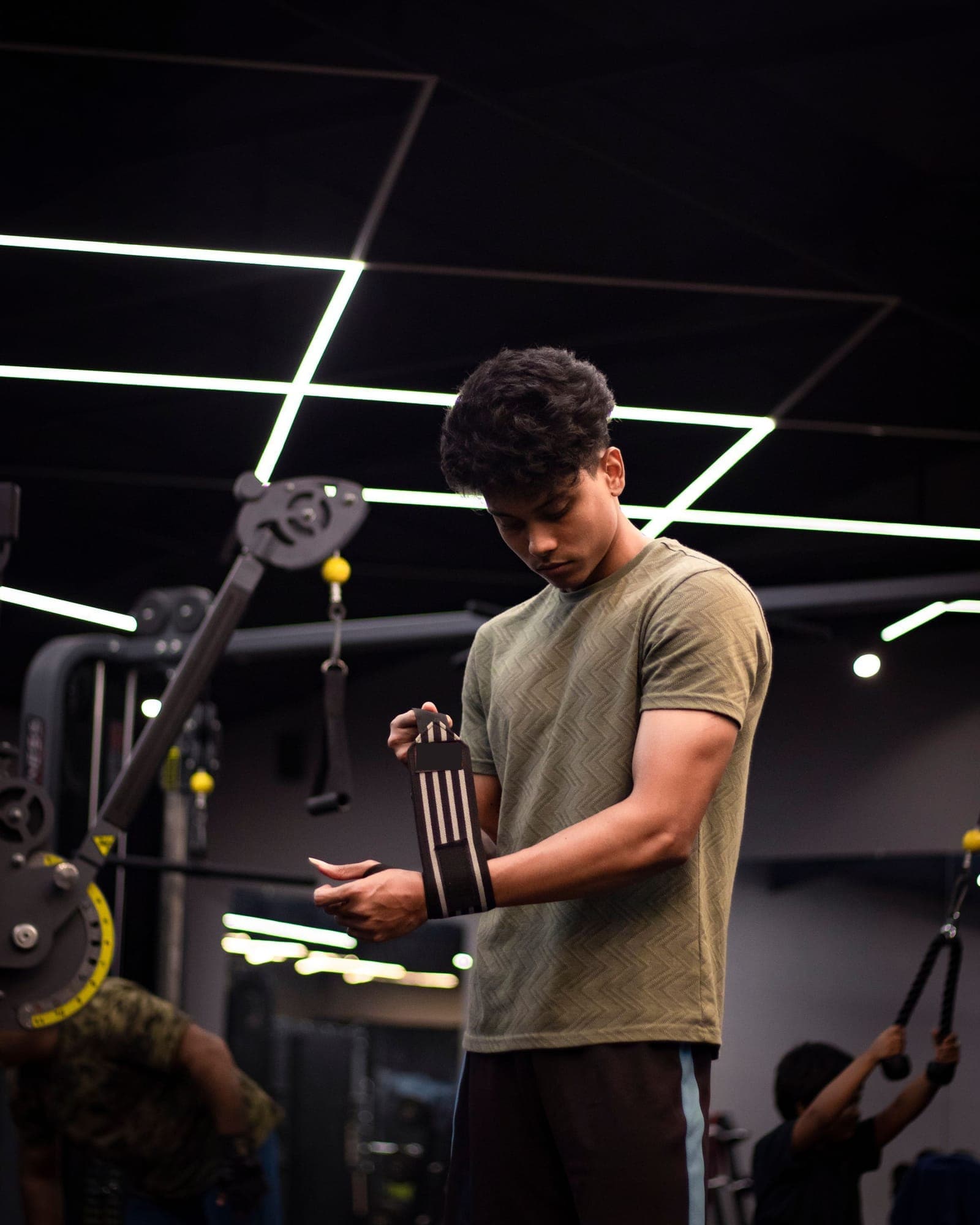A member wrapping his wrists before a workout on a gym floor